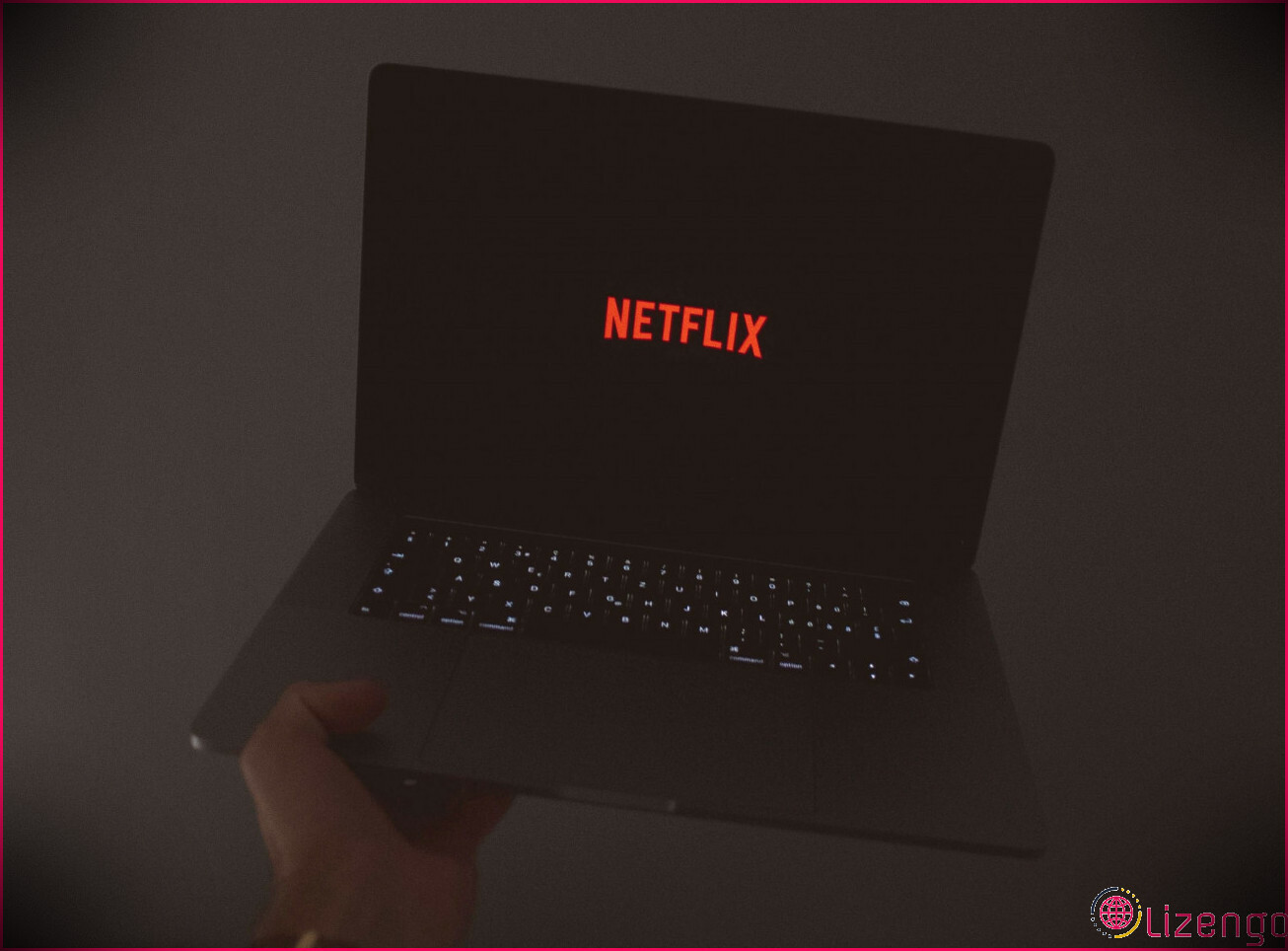 Une personne tenant un ordinateur portable avec le logo Netflix sur l'écran.