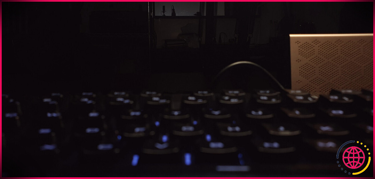 Image sombre et sous-exposée d'un bureau avec un clavier au premier plan