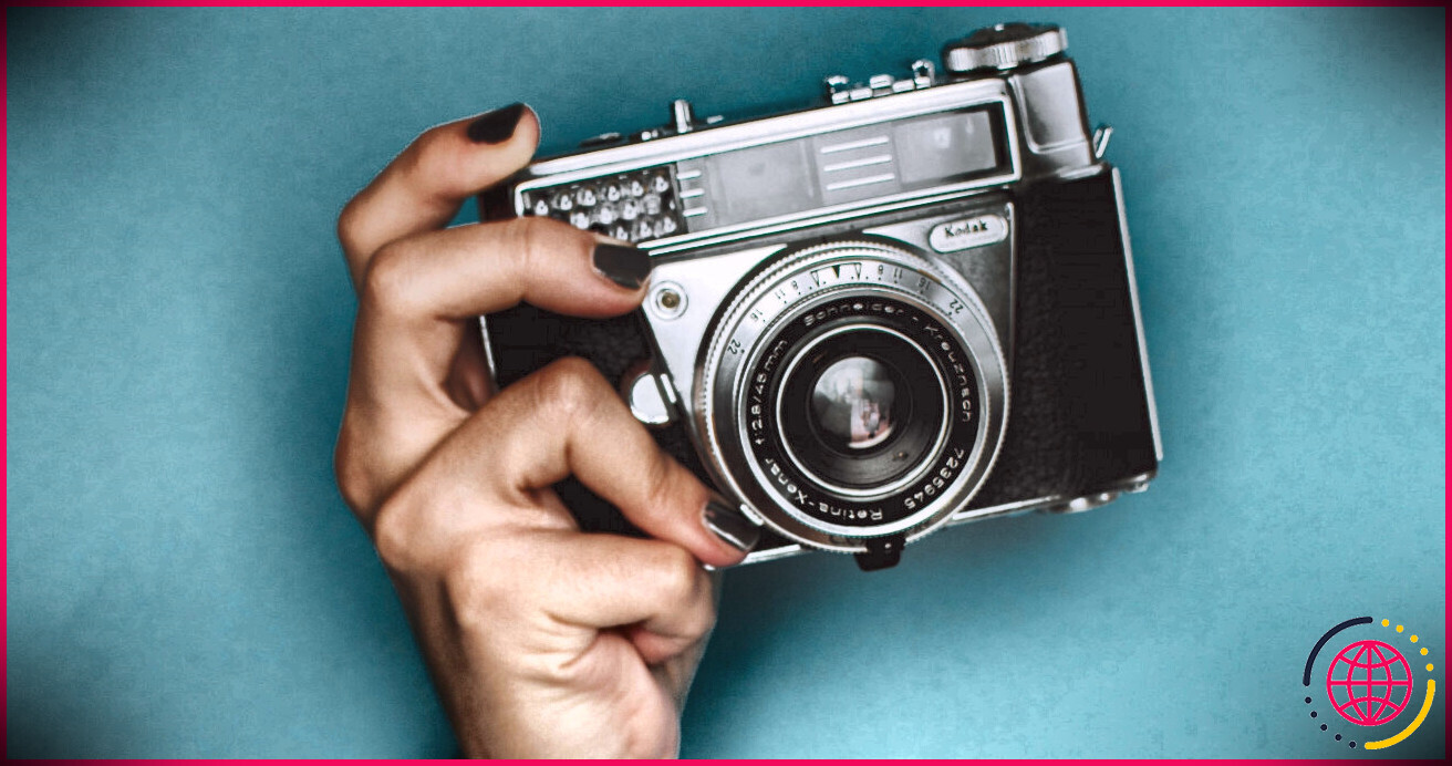 femme tenant un appareil photo vintage