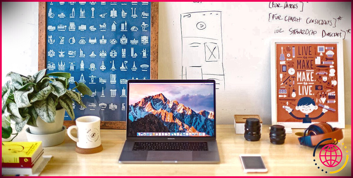 Photo montrant le bureau d'un graphiste avec un ordinateur portable et des notes