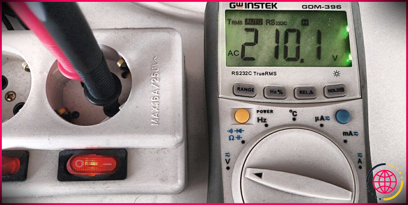 Un multimètre indiquant la tension d'une prise de courant.