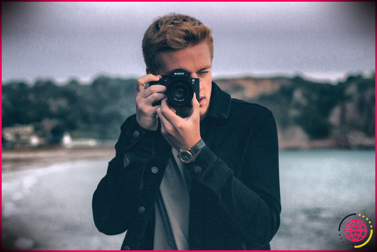photographe utilisant un appareil photo sur la plage